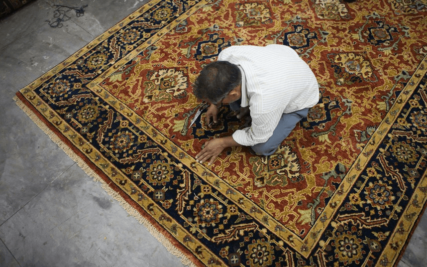 Artisan inspecting a Bhadohi carpet