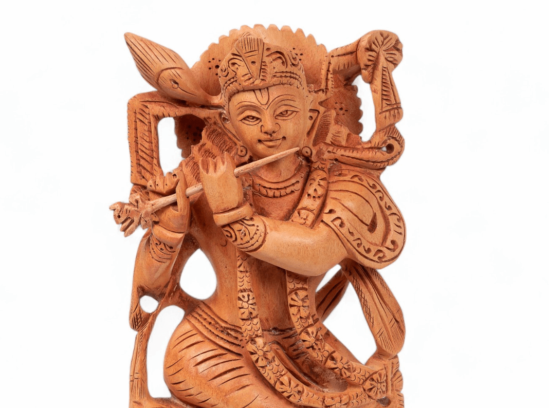 Carved wooden flute-playing Krishna idol